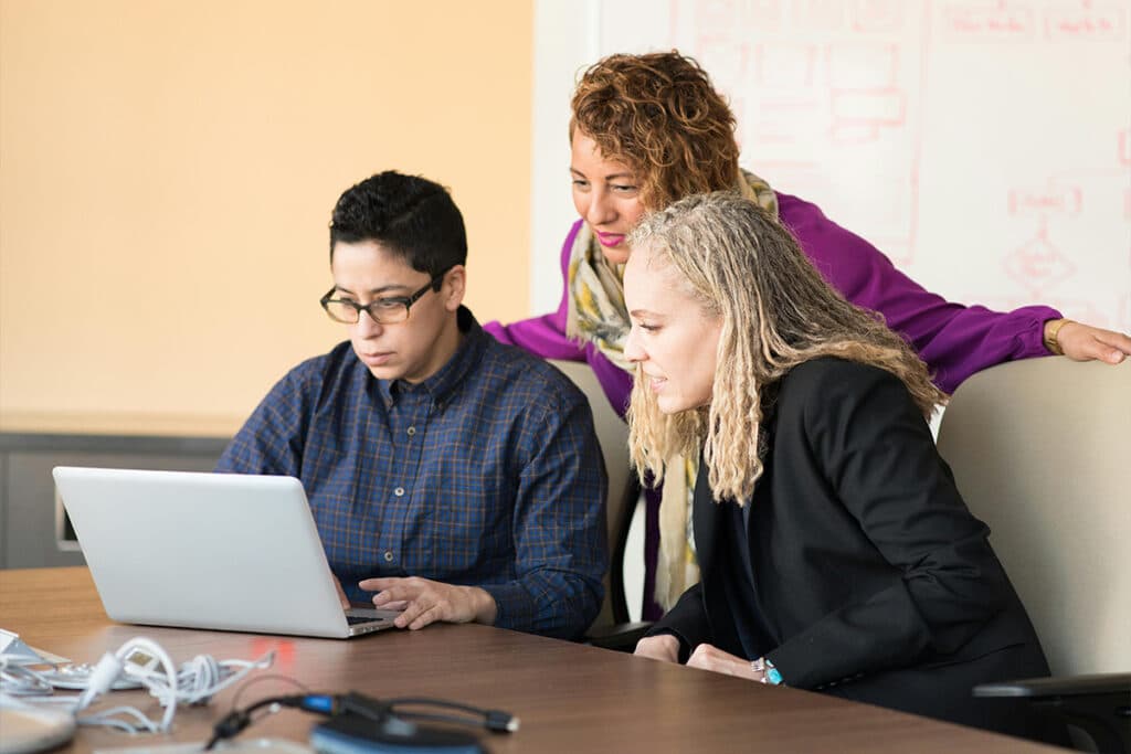 Team collaborating on a laptop using construction management software to streamline project planning.