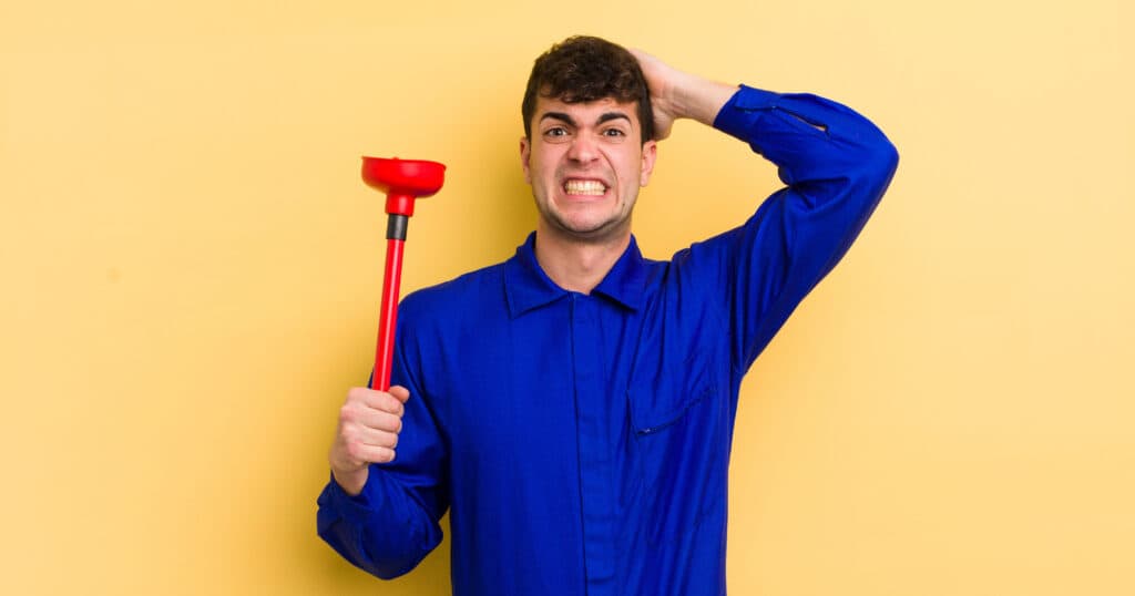 stressed out plumber with red plunger