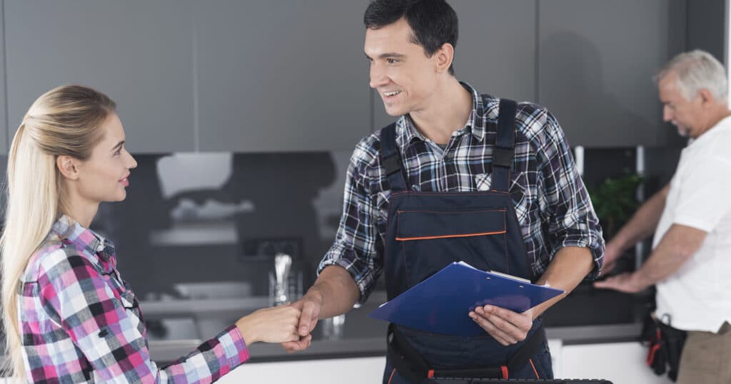 Woman shakes hands with plumber